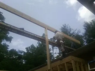 Carpenter setting a ridge beam over a new addition frame — Ice Dam Removal by Roofing Brothers in New Germany