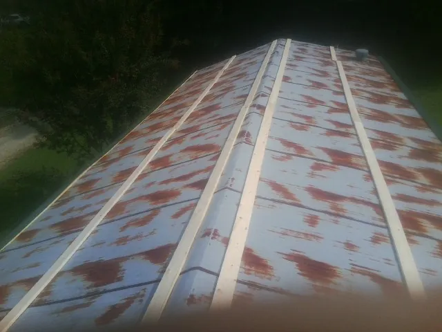 Rusted metal roof panels with new wood purlins before replacement — Storm Damage Roof Repair in New Germany by Roofing Brothers