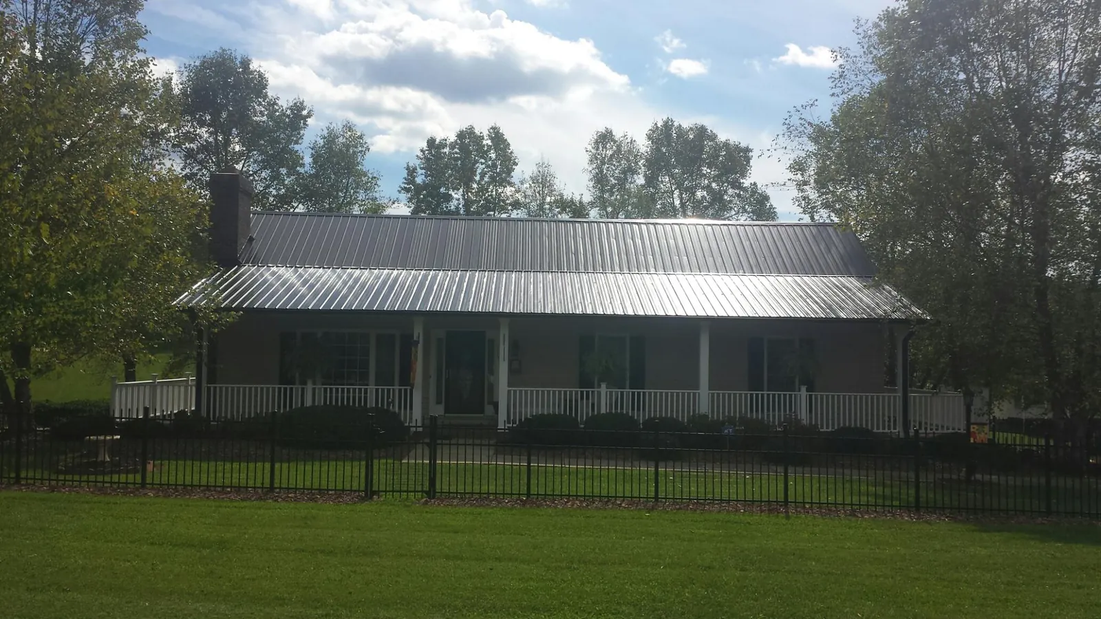 Gray metal roof on a brick ranch with a full width front porch — Gutter Guard Installation work by our crew in New Germany